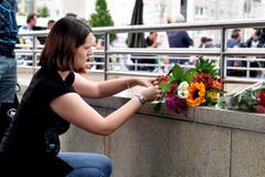 Eine Frau legt Blumen nieder. (Bild: Kerstin Joensson)
