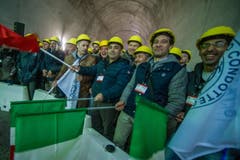 Bauarbeiter feiern den erfolgreichen Durchstoss der Weströhre am Ceneri-Basistunnel. (Bild: Keystone)