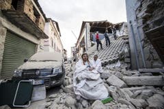 Bewohner von Amatrice auf den Trümmern ihrer Häuser. (Bild: EPA / Massimo Percossi)