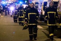 Die Fassungslosigkeit steht diesen Rettungskräften ins Gesicht geschrieben. (Bild: EPA/Etienne Laurent)