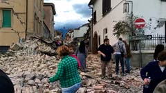 Überlebende in den Trümmern von Amatrice. (Bild: AP Photo / Videostill)