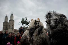 Kostümierte Personen laufen am Umzug "ZüriCarneval 2015" neben dem Grossmünster und dem Hans Waldmann Denkmal. (Bild: ENNIO LEANZA)