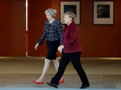 Angela Merkel, eher bescheiden mit schwarzen Halbschuhen, neben Theresa May in rotem Lack. (Bild: Michael Sohn/AP)