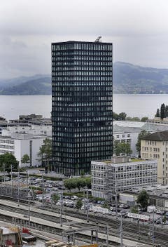 Park-Tower, Zug Der Standort im Zentrum um den Bahnhof erscheint logisch. Mehrere Eigentümerwechsel haben den ursprünglichen Bebauungsplan stark verändert - unter anderem fehlt ein Turm. Die Anbindung im Erdgeschoss an den öffentlichen Raum ist noch nicht sichtbar. Die vertikale Gliederung in Sockel und Regelgeschosse bleibt nur bedingt sichtbar. Die stark gerasterte Fassade stiftet nur wenig Identität. (Bild: Stefan Kaiser / Neue ZZ)