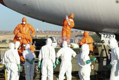 Ärzte und Hilfskräfte verladen den spanischen Priester Miguel Pajares, der sich bei der Arbeit in Liberia mit dem tödlichen Virus infizierte,von einem Flugzeug zu einer Ambulanz. (Bild: Keystone)