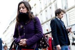 Eine junge Frau betet vor dem Cafe Carillon in Paris. (Bild: EPA/Yoan Valat)