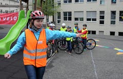 Instruktorin Flavia Zimmermann zeigt den Kindern, wie die Armzeichen vor dem Abbiegen sind. (Bild: Markus von Rotz (Neue NZ))