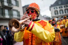 Eine kostümierte Person spielt Trompete und läuft am Umzug "ZüriCarneval 2015". (Bild: ENNIO LEANZA)