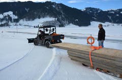 Andi Kaufmann hilft Louis Schönbächler beim Holztransport für den Bau einer Brücke übers Eis, das den untersten Teil des Sihlsees bedeckt. (Bild: Charly Keiser / Neue SZ)