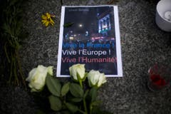 Mit einem Poster und Blumen wird vor der französischen Botschaft in Berlin der Opfer gedacht. (Bild: AP/Markus Schreiber)