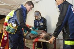 Eine verletzte Frau liegt auf der Rettungsliege und der Notarzt versorgt sie. (Bild: Edi Ettlin)