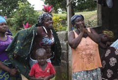 Liberianische Angehörige trauern um einen Verwandten, der an Ebola gestorben ist und gerade weggetragen wird. (Bild: Keystone)