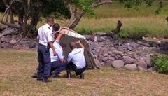 Französische Polizisten untersuchen das gefundene Wrackteil. (Bild: Keystone)
