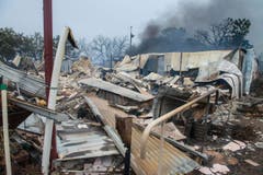 Angesichts kühlerer Wetterbedingungen und schwächerer Winde gelang es den Einsatzkräften, das Feuer langsam unter Kontrolle zu bekommen. (Bild: Keystone)