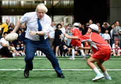 Boris Johnson weicht einem Kind aus. (Bild: AP / Stefan Rousseau)