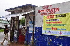 Ein liberischer Soldat bewacht den Kontrollpunkt, damit keine Menschen in die von Ebola befallene liberische Hauptstadt gelangen und sich das Virus damit noch weiter verbreitet. (Bild: Keystone)