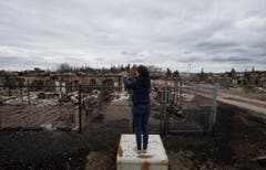 Eine Reporterin macht sich Bilder von der Zerstörung. (Bild: Ryan Remiorz/The Canadian Press via AP)