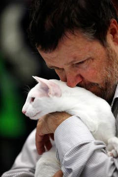 Stefan Ruf aus Brione schmust mit seiner weissen Siamesen-Katze. (Bild: Christof Borner-Keller / Neue ZZ)
