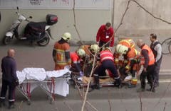 Nach der Explosion an der Metrostation Maelbeek im Zentrum von Brüssel: Sanitäter kümmern sich an der betroffenen Metrostation um eine verletzte Person. (Bild: APTN via AP)