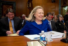 Hillary Clinton hat im Februar 2012 Probleme, sich richtig auf den Stuhl zu setzen und bricht deshalb in Gelächter aus. (Bild: Keystone)