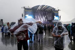 Diese Besucher wollen sich vom Regen schützen. (Bild: Keystone / Peter Klaunzer)