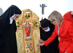 Frau Mutter, Schwester Maria Jacinta, und die frühere Weberin Schwester Maria Andrea (von links), zeigen der Oberdorfer Gemeindepräsidentin Judith Odermatt ein prächtiges altes Messgewand. (Bild: Romano Cuonz / Neue NZ)