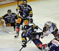Die Zuger Jussi Markkanen, Andy Wozniewski und Alessandro Chiesa gegen Berns Tristan Scherwey (von links). (Bild: Keystone)