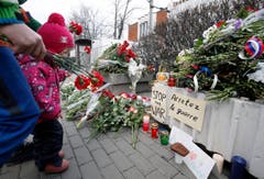Ein Kind legt vor der französischen Botschaft in Moskau Blumen nieder. (Bild: EPA/Sergei Chrikov)