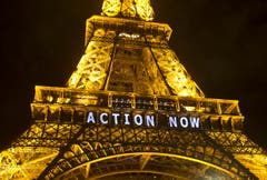 Auch der alte Eiffelturm muss für Slogans hinhalten. (Bild: AP Photo/Michel Euler)