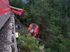 Riesiges Glück hatte die Bahnreisenden im ersten Wagen nach der Lokomotive. Gemäss Angaben eines Passagiers stürzte dieser Wagen etwa 20 Meter vom Trassee und blieb im Steilhang der Schinschlucht an Bäumen hängen. (Bild: Kantonspolizei Graubünden)