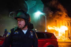 Ein Polizeioffizier vor einem brennenden Haus in der Kravallnacht. (Bild: Keystone/EPA/Noah Scialom)