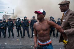 Ein junger Demonstrant wird von einem älteren Herrn zurückgehalten. (Bild: Keystone/EPA/Noah Scialom)