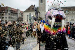 Kostümierte Personen werfen Konfetti und laufen am Umzug "ZüriCarneval 2015". (Bild: ENNIO LEANZA)