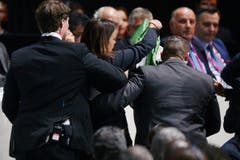 Eine der beiden Frauen wird von Sicherheitskräften weggeführt. (Bild: EPA/WALTER BIERI)