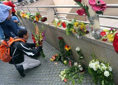 Ein Mann verleiht seiner Trauer Ausdruck und legt Blumen nieder. (Bild: Keystone)