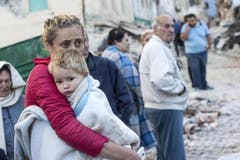 Eine Mutter hält ihren Sohn fest in den Armen. (Bild: EPA / Massimo Percossi)