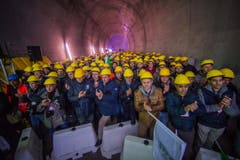 Bauarbeiter feiern den erfolgreichen Durchstoss der Weströhre am Ceneri-Basistunnel. (Bild: Keystone)