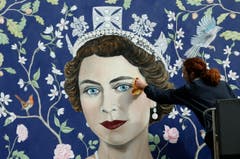 London schmückt sich: Ein Wandbild der jungen Queen, ein Werk des Künstlers Frederick Wimsett, erhält letzte Retouchen. (Bild: Keystone)