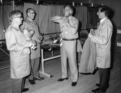 Joachim Fuchsberger war an den Olympischen Spielen von München im Jahr 1972 einer der Hauptsprecher. Hier probiert er, begutachtet von drei Schneidern, seine neue Uniform. (Bild: Keystone)
