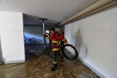 Ein Feuerwehrmann macht im Keller sauber. (Bild: Manuel Nagel)