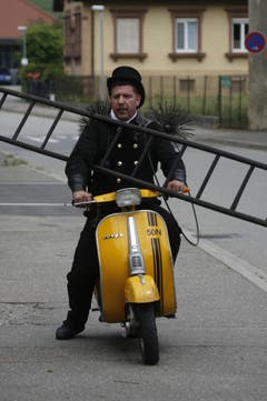 Wozu braucht man ein Auto, wenn man alles auf eine Vespa bekommt? Dachte sich wohl dieser Schornsteinfeger. (Bild: Keystone)