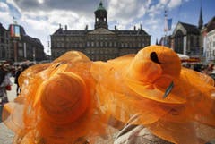 Hüte in orange bedecken die Köpfe dieser zwei Damen. (Bild: Keystone)