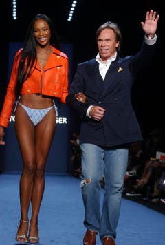 Das Beste kommt zum Schluss: Hilfiger schreitet mit Supermodel Naomi Campbell nach der Präsentation seiner Frühlingskollektion 2005 über den Laufsteg und bedankt sich bei den Zuschauern. (Bild: Keystone)
