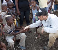 Als Unicef-Botschafter besucht Robbie Williams 2010 nach dem Erdbeben auf Haiti Kinder in einem Zeltlager. (Bild: Keystone)