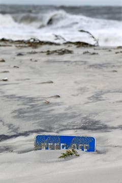 Durch «Sandy» ist so viel Sand angespült worden, dass nur noch ein kleiner Teil der Warntafel in Cape May aus den Dünen hervorlugt. (Bild: Keystone)
