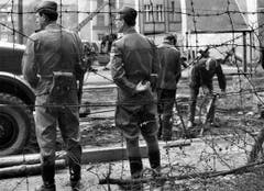 Soldaten der Volksarmee brechen am 7. Mai 1969 unter strengster Bewachung der Volkspolizei ein altes und sprödes Stück der Berliner Mauer bei Neukölln in Ost-Berlin ab, um danach eine neue Mauer zu errichten. (Bild: Keystone)