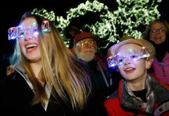 Diese Geschwister in Boston feiern den Jahreswechsel mit einer speziellen Brille. (Bild: Keystone)