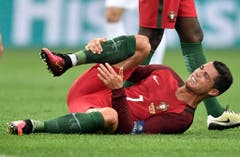Nach einem Tackle hält sich der Portugiesische Fussballspieler Christiano Ronaldo das Bein. (Bild: Keystone)
