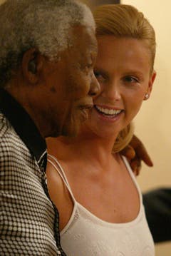 Friedensnobelpreistärger Nelson Mandela scherzt mit Oscargewinnerin und Landfrau Charlize Theron (2004). (Bild: Keystone)