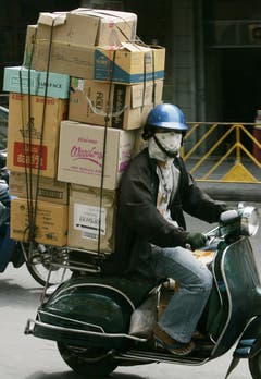 In Thailand fahren die Paketkuriere die Bestellungen ihrer Kunden ebenfalls auf der Vespa aus. (Bild: Keystone)